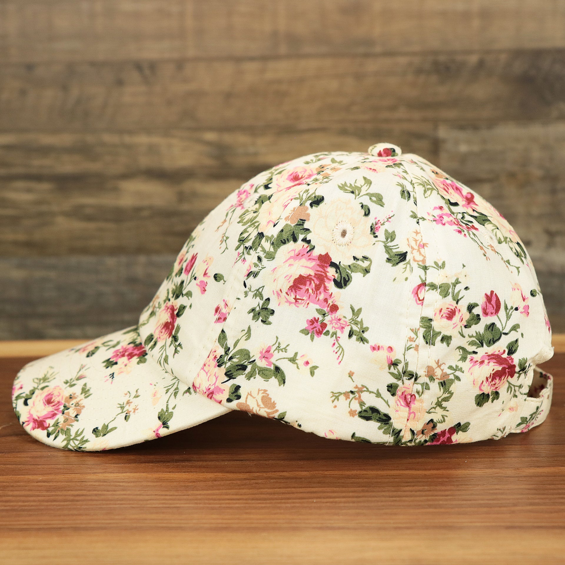 The wearer's left of the Kid’s Floral Print Blank Adjustable Baseball Hat | Youth Cream Dad Hat