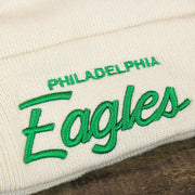 The Philadelphia Eagles Wordmark on the Philadelphia Eagles Script Cuffed Winter Beanie With Pom Pom | Ivory Winter Beanie