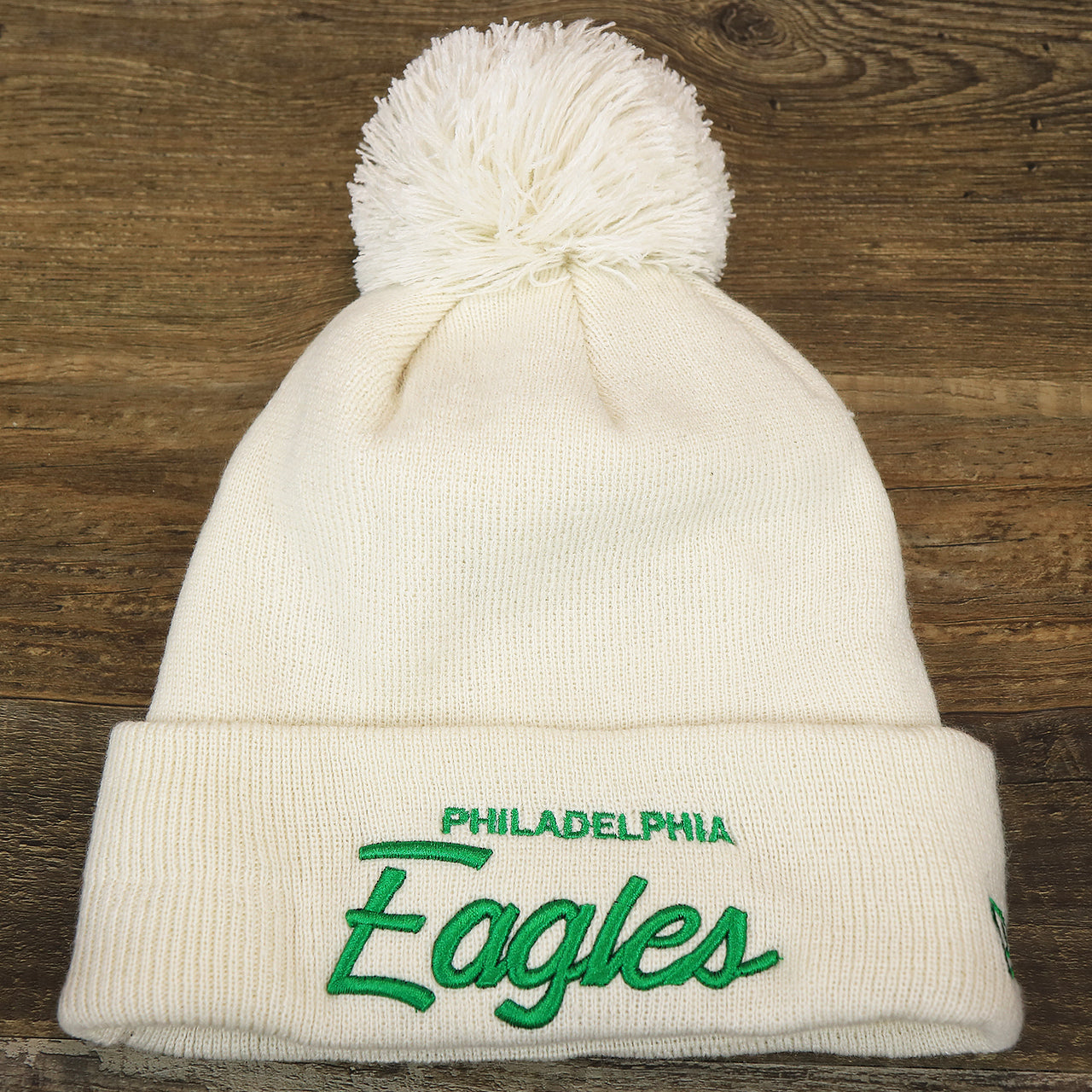 The front of the Philadelphia Eagles Script Cuffed Winter Beanie With Pom Pom | Ivory Winter Beanie