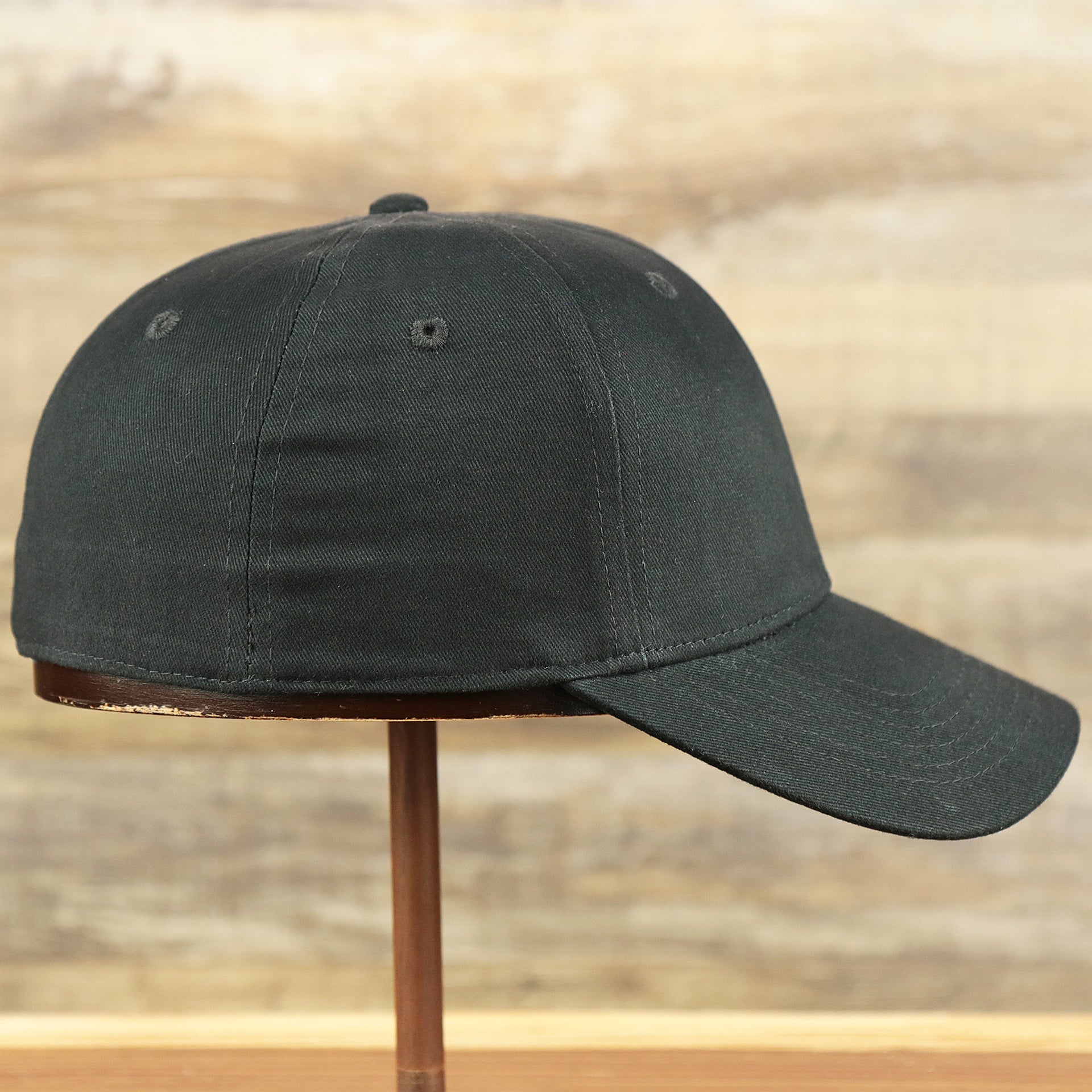 The wearer's right on the Youth Jet Black Structured Cotton Blank Flexfit Cap | Kid’s Black Stretch Fit Caps