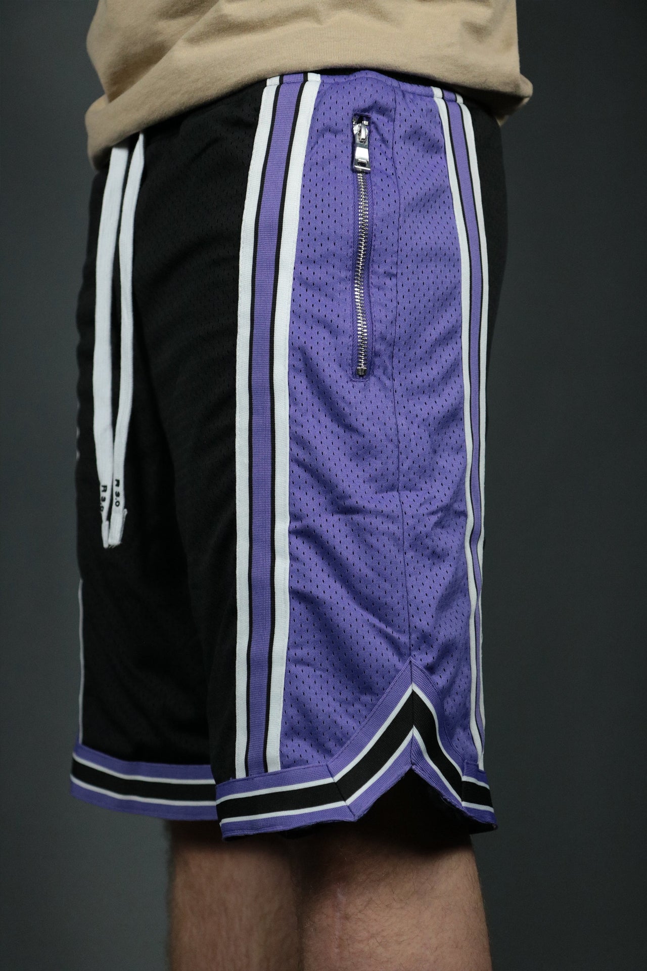 A pair of black purple Sacramento mens running shorts with zipper pockets and white stripes.