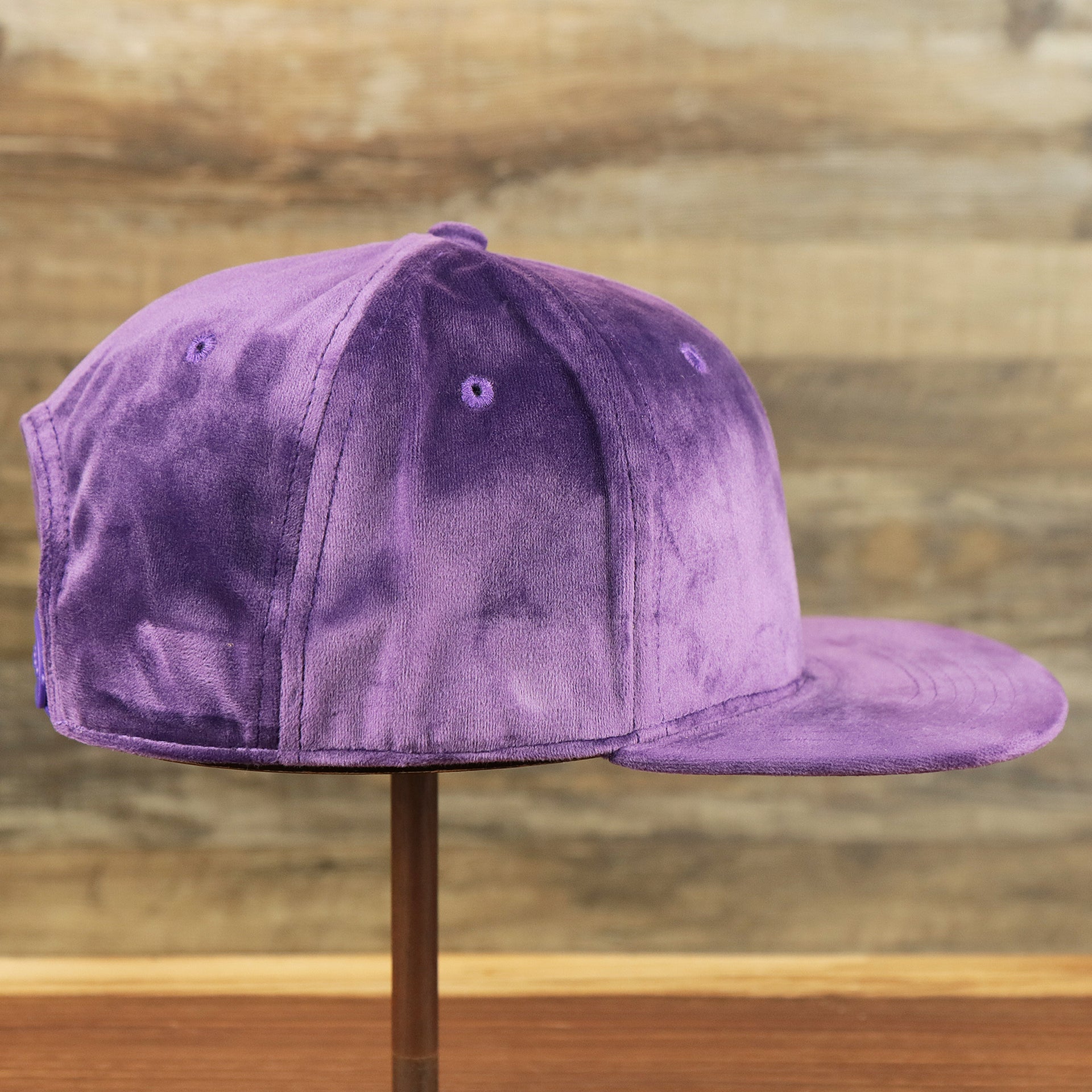 The wearer's right on the Velour Blank Concord Grape Snapback Cap | Purple Snap Cap