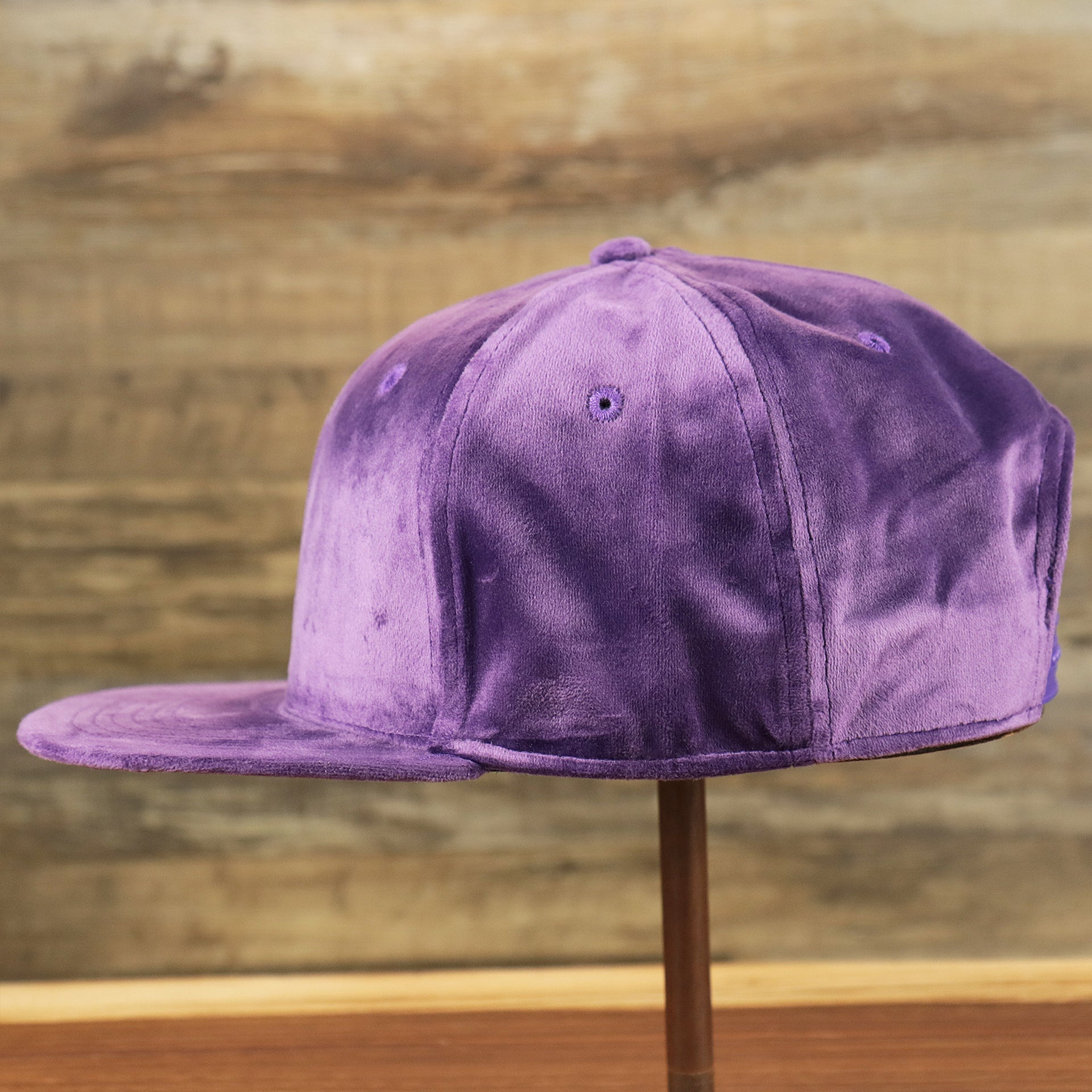 The wearer's left of the Velour Blank Concord Grape Snapback Cap | Purple Snap Cap