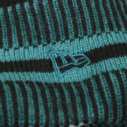 The New Era Logo on the Philadelphia Eagles Patch 1933 On Field Striped Eagles Colorway Pom Pom Winter Beanie | Black and Midnight Green Winter Beanie