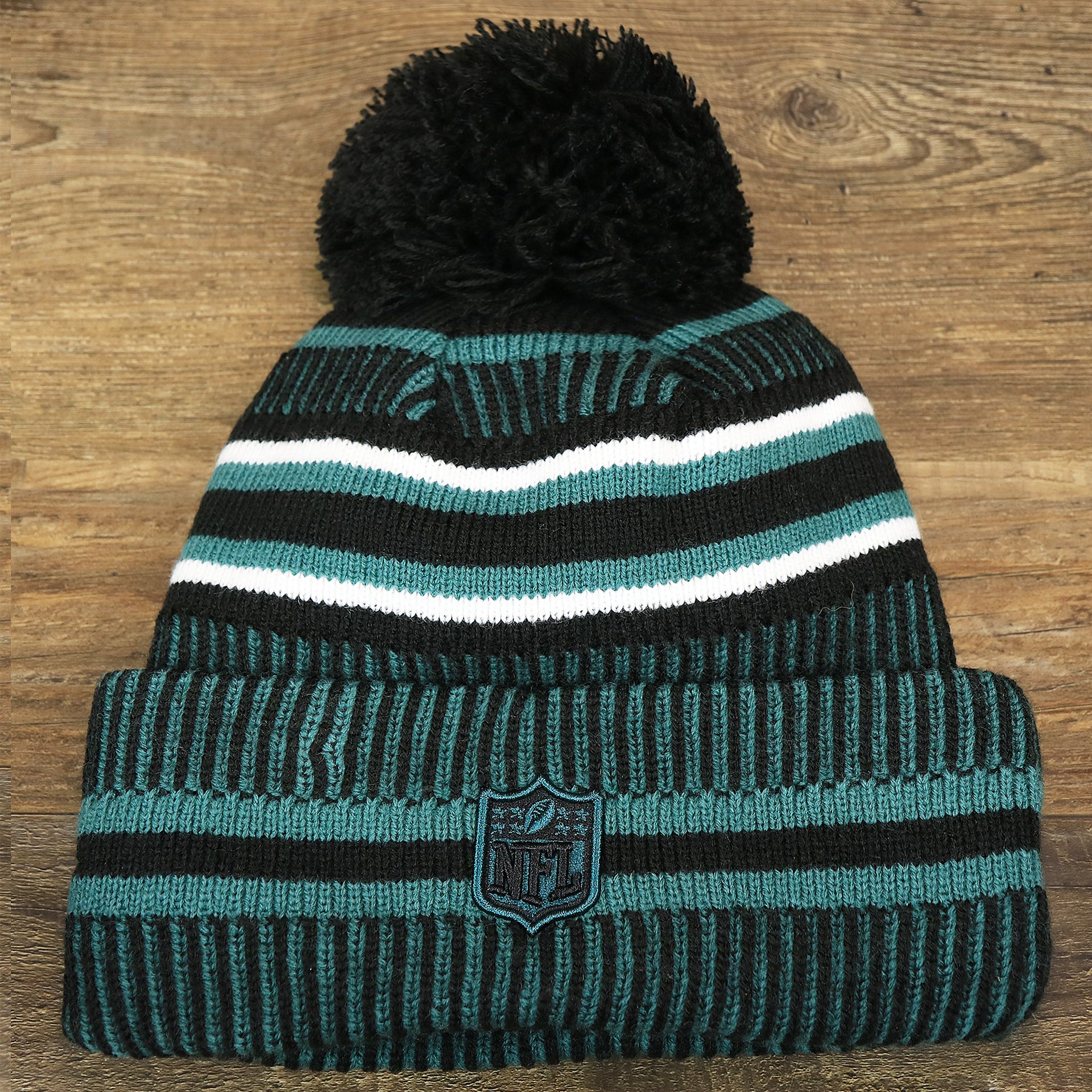 The backside of the Philadelphia Eagles Patch 1933 On Field Striped Eagles Colorway Pom Pom Winter Beanie | Black and Midnight Green Winter Beanie