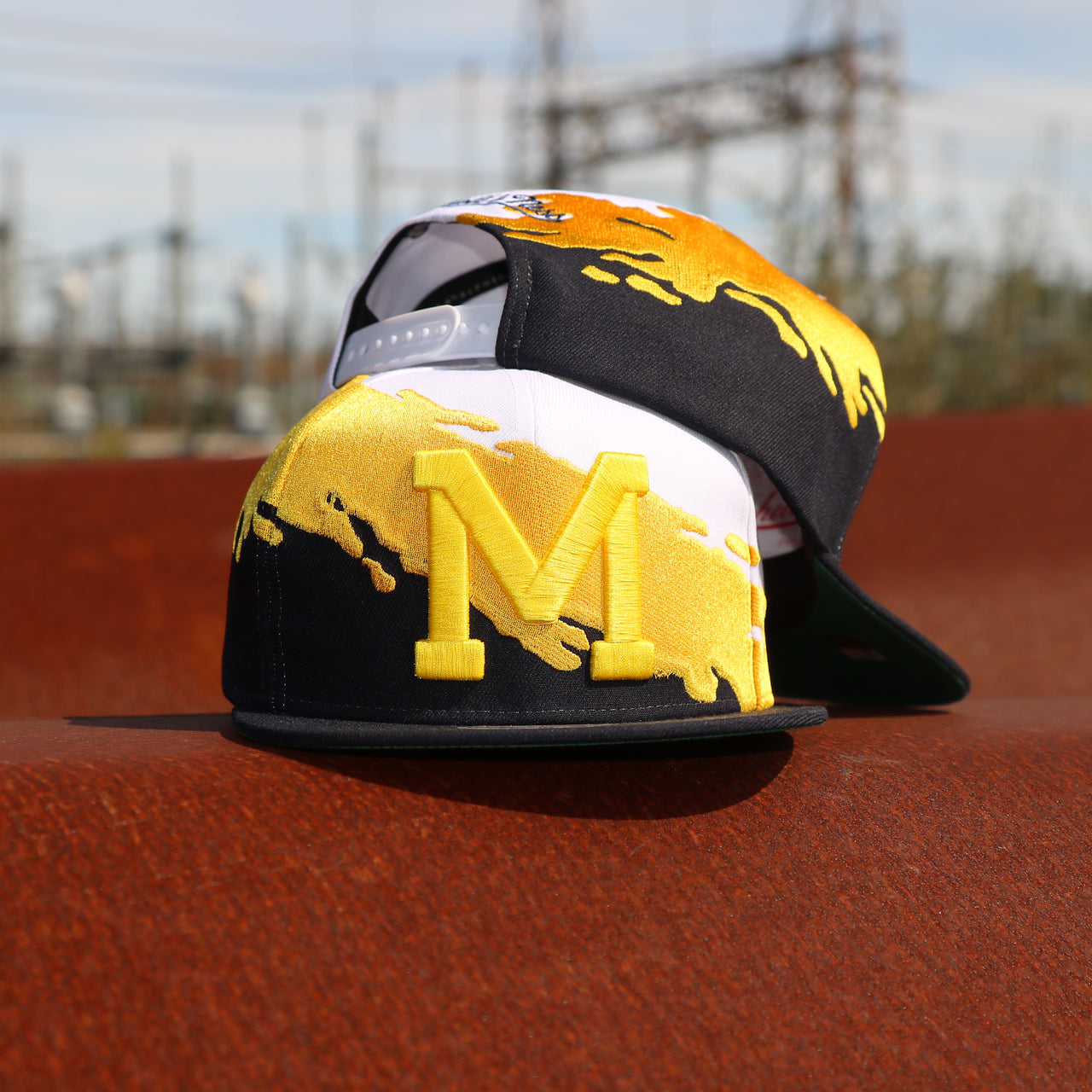 front and back of the University of Michigan Vintage Retro NCAA Paintbrush Mitchell and Ness Snapback Hat | Yellow/Navy Blue/White