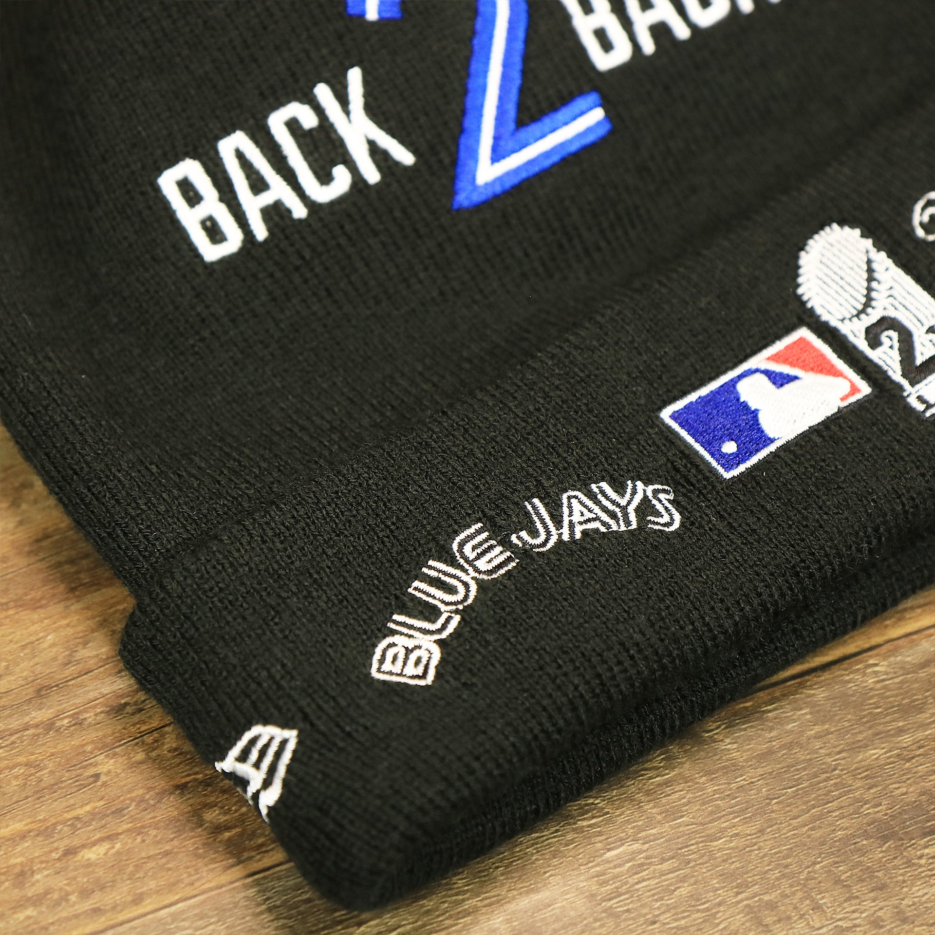 The Blue Jays Wordmark on the Toronto Blue Jays All Over World Series Side Patch 2x Champion Knit Cuff Beanie | New Era, Black