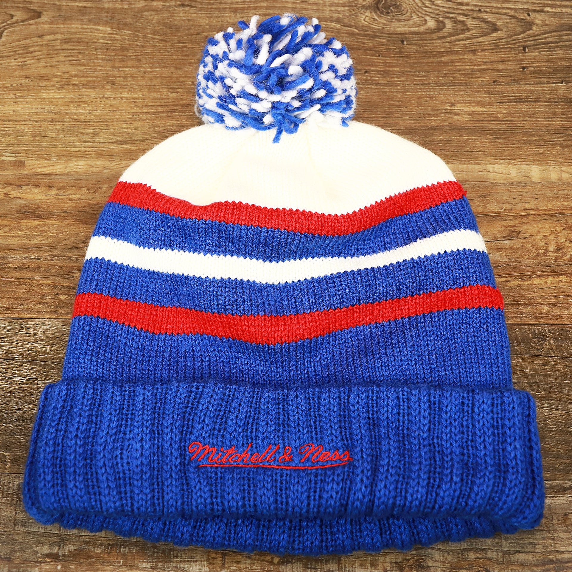 The backside of the Los Angeles Clippers Cursive Wordmark Blue Cuff Pom Pom Winter Beanie | Blue Striped Winter Beanie