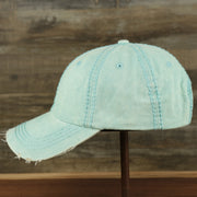 The wearer's left of the Washed Pigment Blank Distressed Baseball Hat | Washed Mint Dad Hat