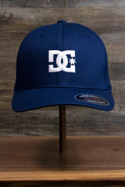 the front of the Navy Blue Skater Hat | DC Shoes Blue Bottom Navy Flexfit Cap is made of navy blue twill and has a white embroidered DC logo on it