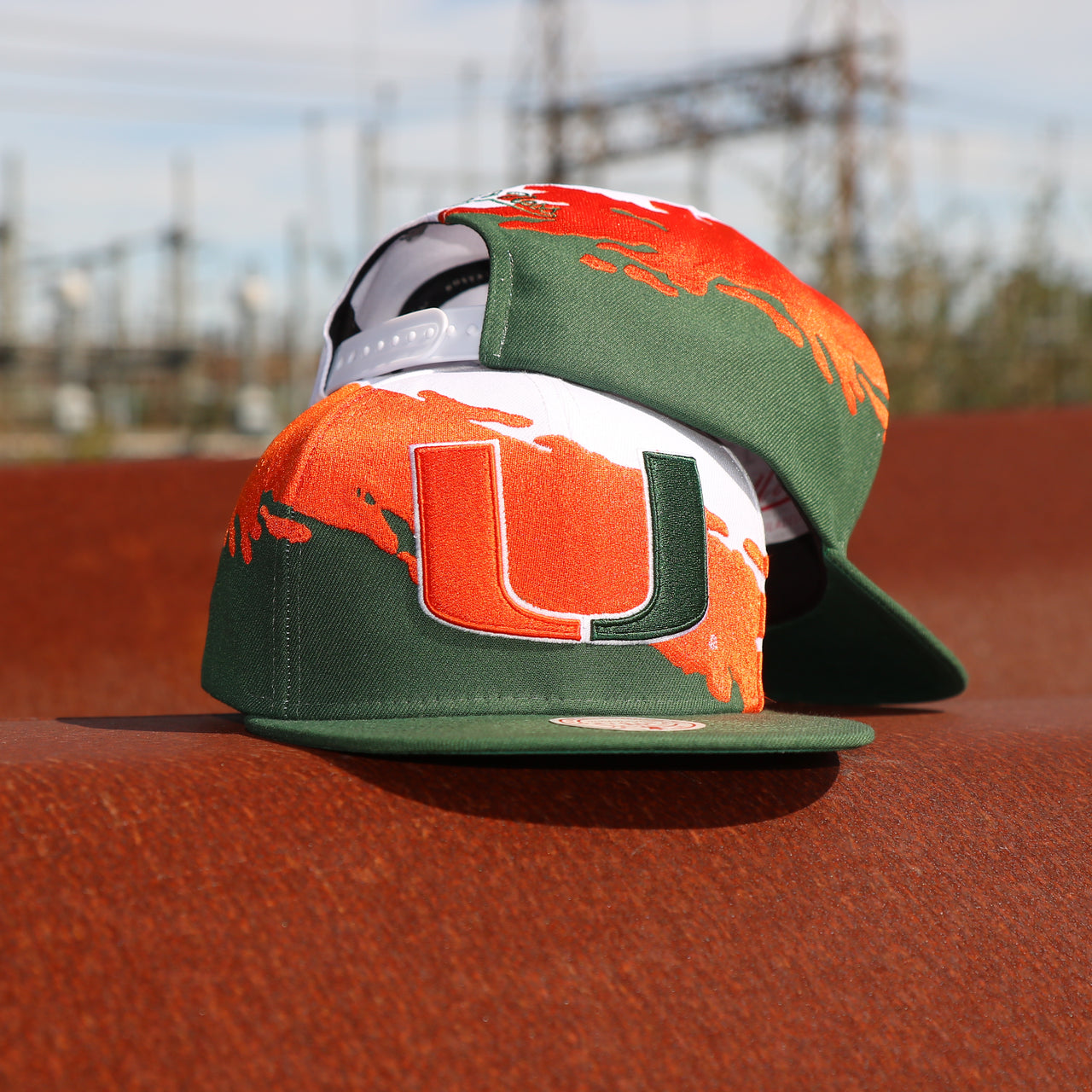 front and back of the University of Miami Vintage Retro NCAA Paintbrush Mitchell and Ness Snapback Hat | Orange/Green/White
