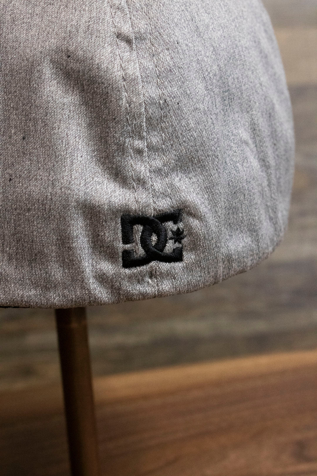the Light Gray Bentbrim Skater Hat | DC Shoes Black Bottom Heather Gray Flexfit Cap has a tiny black DC logo on the back