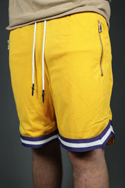 A model wearing the Los Angeles basketball shorts with zipper pockets by Jordan Craig.