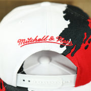 mitchell and ness logo on the back of the Chicago Bulls Vintage Retro NBA Paintbrush Mitchell and Ness Snapback Hat | Red/White/Black
