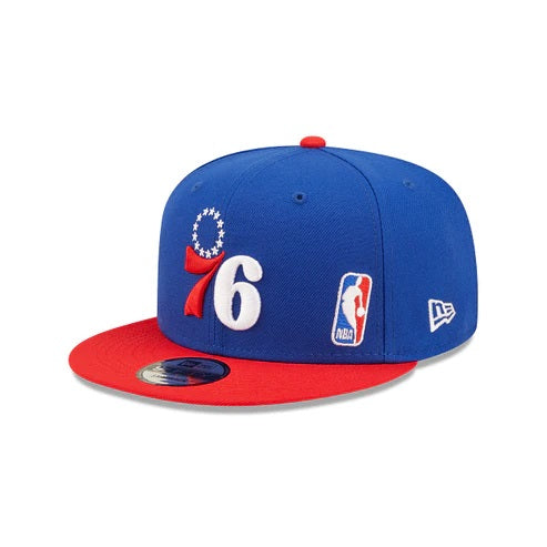 The wearer's left on the Philadelphia 76ers Red Letter Arch Vintage Green Bottom NBA 9Fifty Snapback Hat | Back Letter Arch Royal Blue 9Fifty