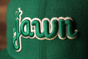 the word jawn is in kelly green and white, based on the old kelly green eagles colors Grey Bottom Fitted Cap | Jawn Kelly Green Gray Bottom Fitted Hat