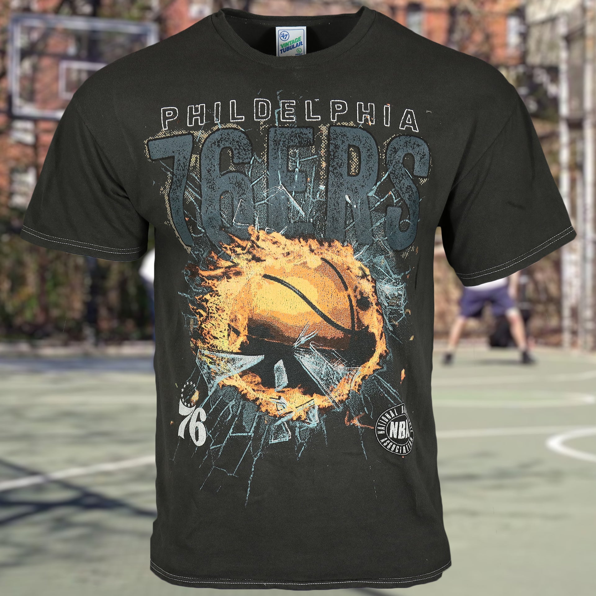 front side of the Philadelphia 76ers Flaming Basketball Shattering Glass Vintage Tubular Distressed T-Shirt | Flint Black