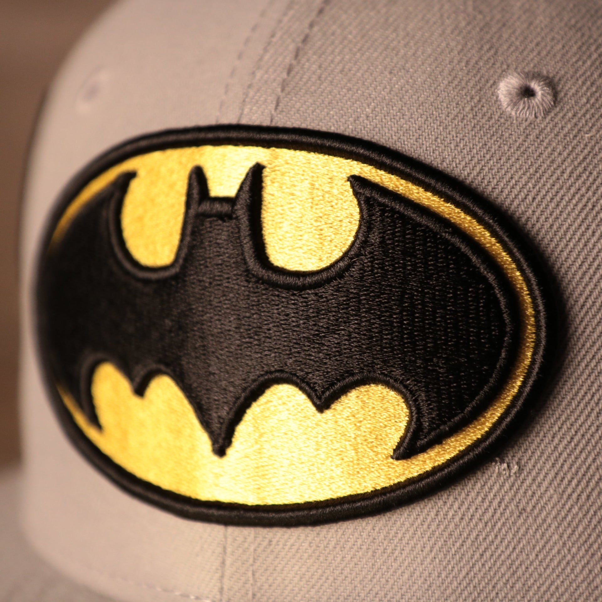 Batman Grey Bottom Fitted Cap | Batman Superhero Gray Bottom Fitted Hat the batman logo has the batman bat in front of a yellow oval