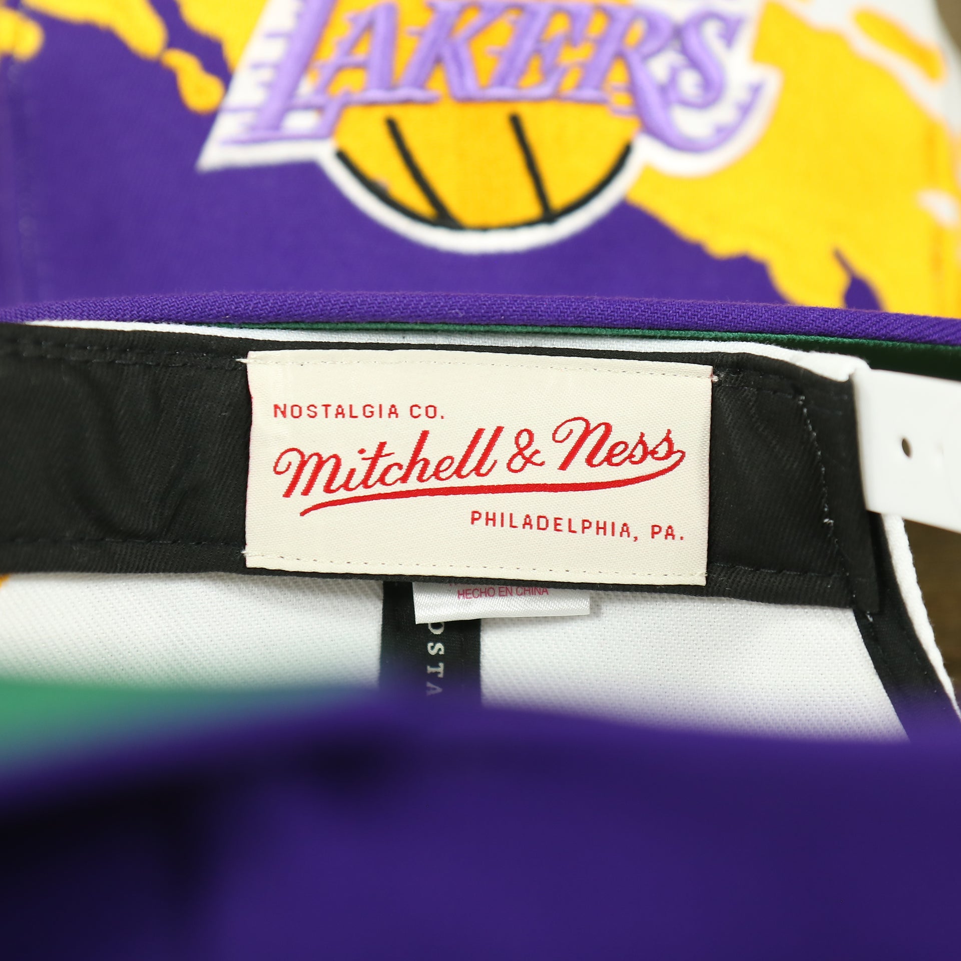 mitchell and ness tag on the Los Angeles Lakers Vintage Retro NBA Paintbrush Mitchell and Ness Snapback Hat | Purple/White/Yellow
