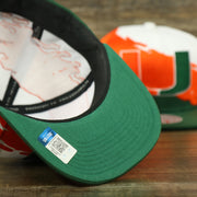 bottom of the University of Miami Vintage Retro NCAA Paintbrush Mitchell and Ness Snapback Hat | Orange/Green/White