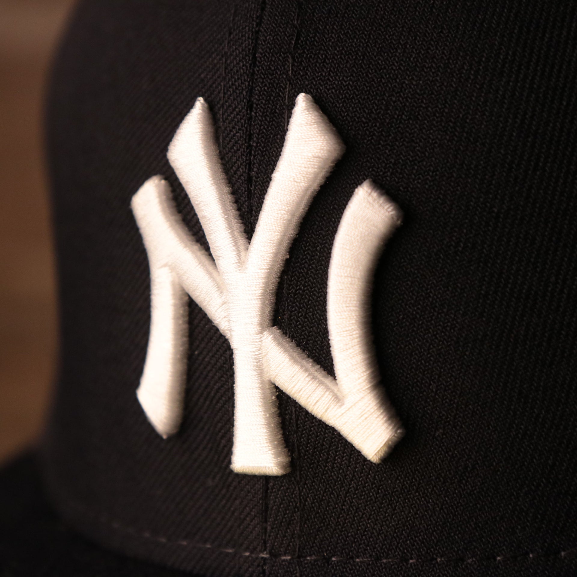 the yankees logo on the front of this cap is white Yankees On-Field Grey Bottom Fitted Cap | New York Yankees 1996 Game Worn World Series Side Patch Gray Under Brim 59Fifty Fitted Hat