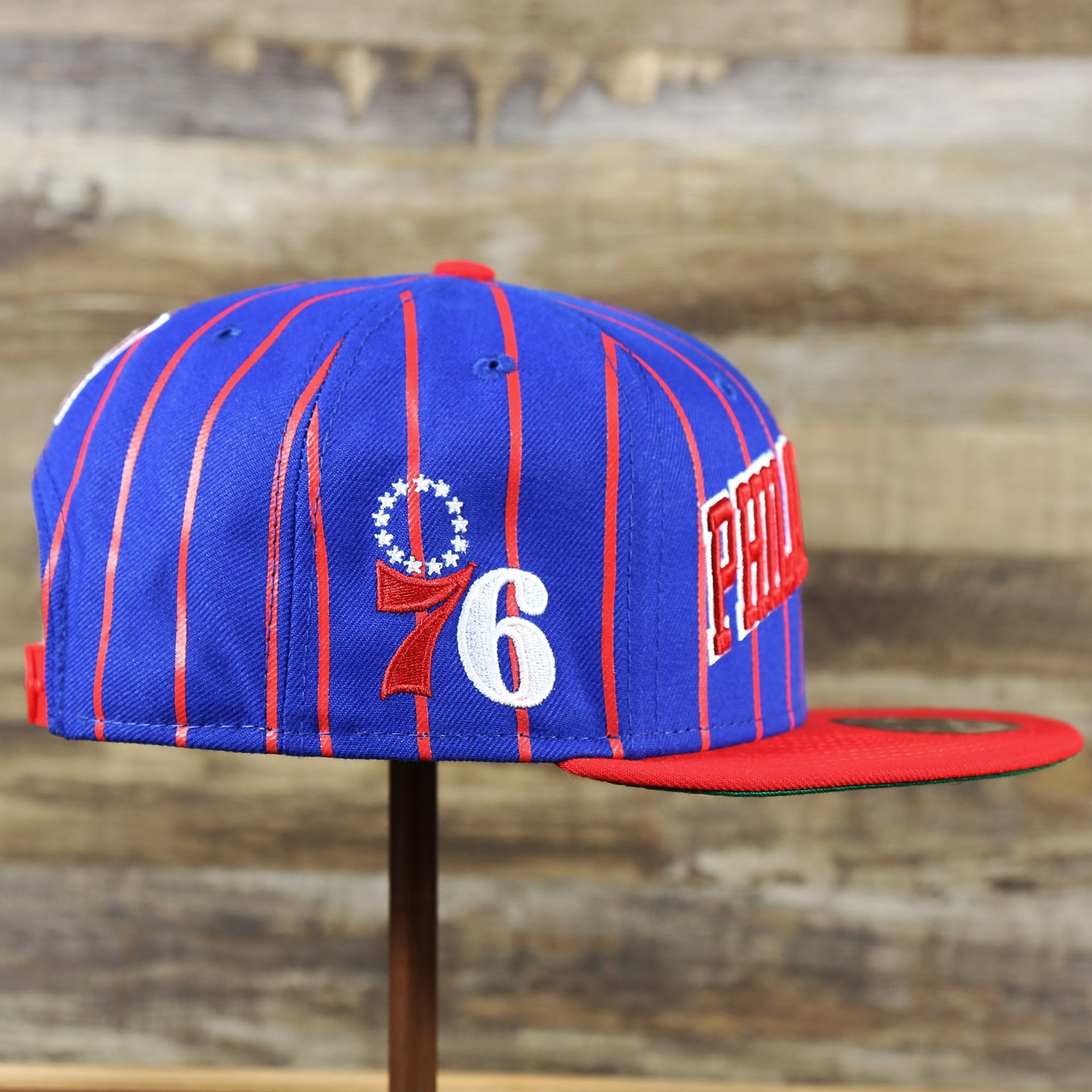 The wearer's right of the Philadelphia 76ers City Arch Striped 9Fifty Snapback Cap | Royal Blue 9Fifty Cap