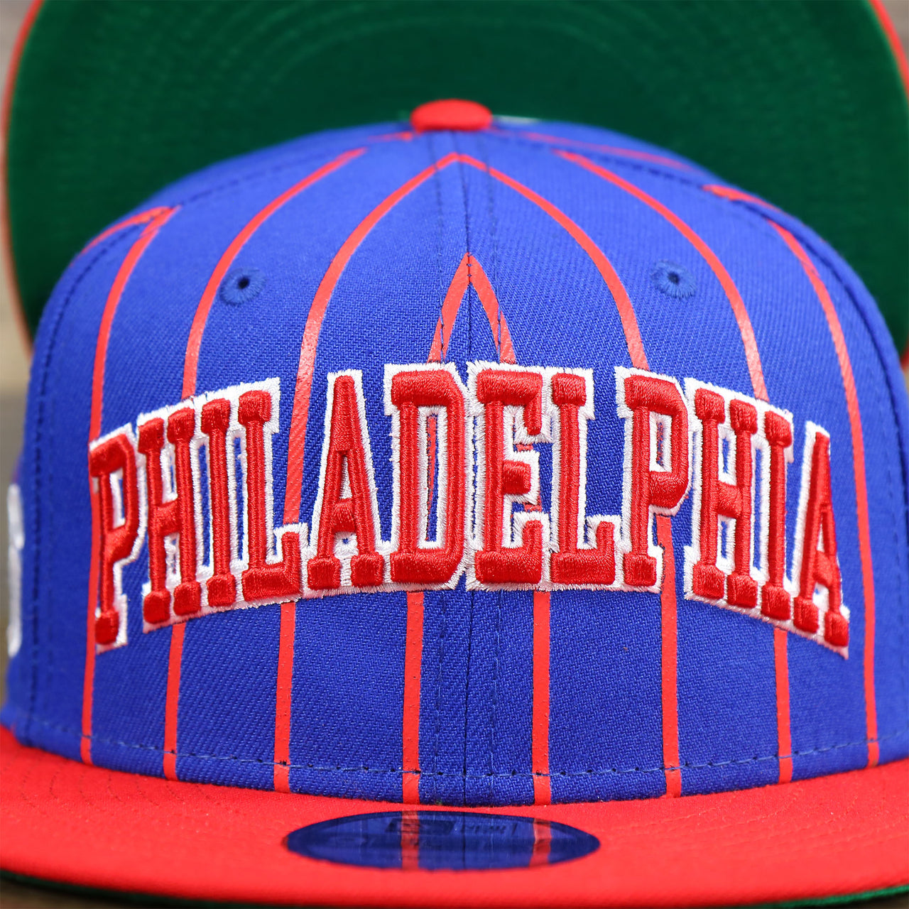 The Philadelphia Wordmark on the Philadelphia 76ers City Arch Striped 9Fifty Snapback Cap | Royal Blue 9Fifty Cap
