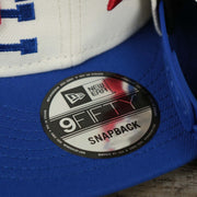 The 9Fifty Sticker on the Philadelphia 76ers NBA 2022 Draft Gray Bottom 9Fifty Snapback | New Era Cream/Royal Blue