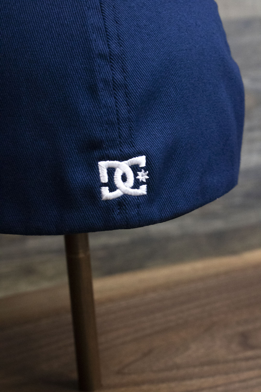 the back of the Navy Blue Skater Hat | DC Shoes Blue Bottom Navy Flexfit Cap has a tiny DC Shoes logo on it