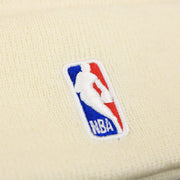 The NBA Jerry West Logo on the Philadelphia 76ers NBA City Series Cracker Liberty Bell Winter Beanie | Cream Winter Beanie