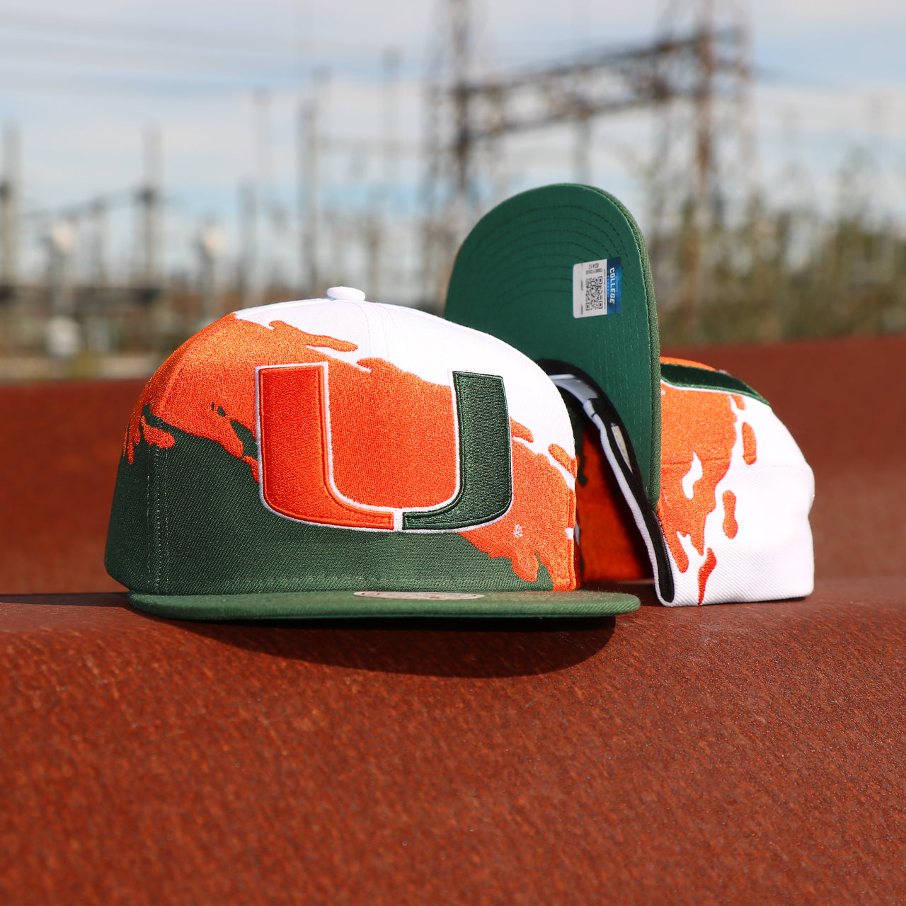 front and bottom of the University of Miami Vintage Retro NCAA Paintbrush Mitchell and Ness Snapback Hat | Orange/Green/White