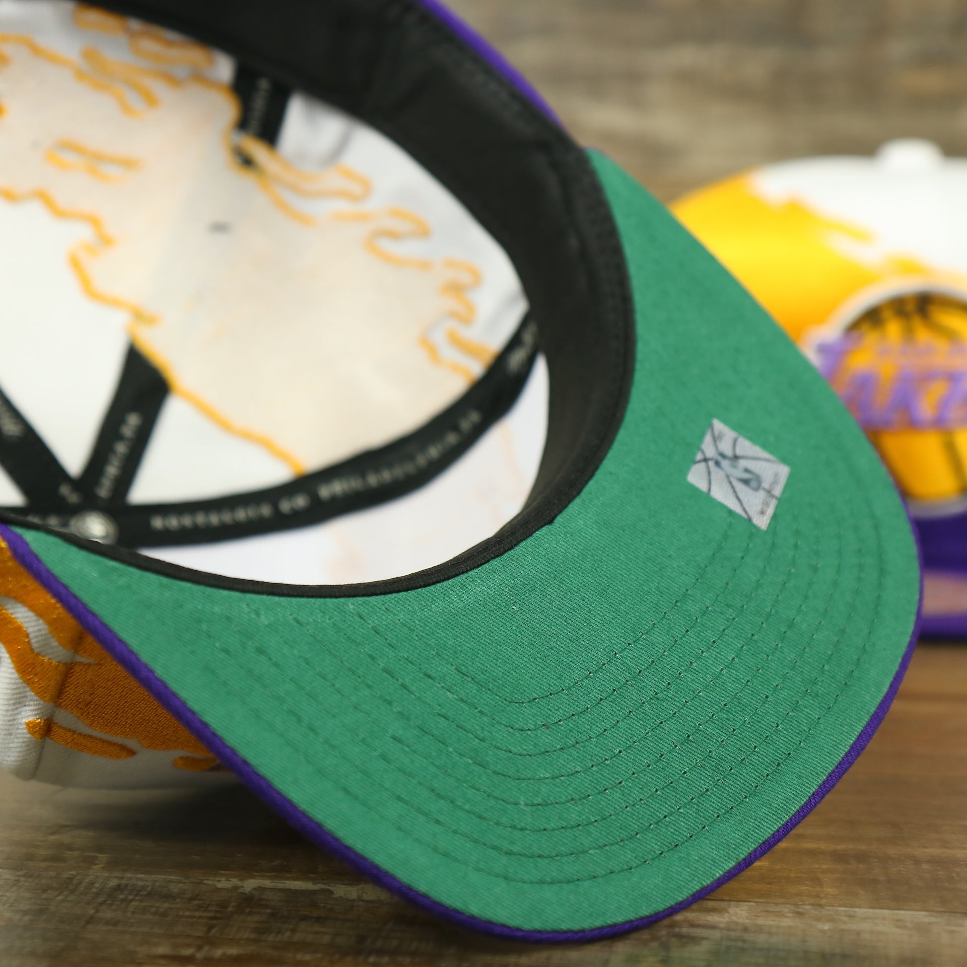 green underbrim on the Los Angeles Lakers Vintage Retro NBA Paintbrush Mitchell and Ness Snapback Hat | Purple/White/Yellow