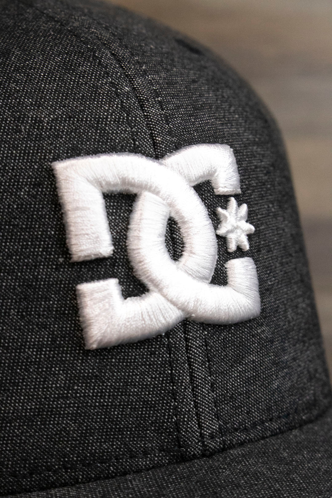 the DC logo on the Dark Gray Bentbrim Skater Hat | DC Shoes Black Bottom Heather Gray Flexfit Cap is made of white puff embroidery