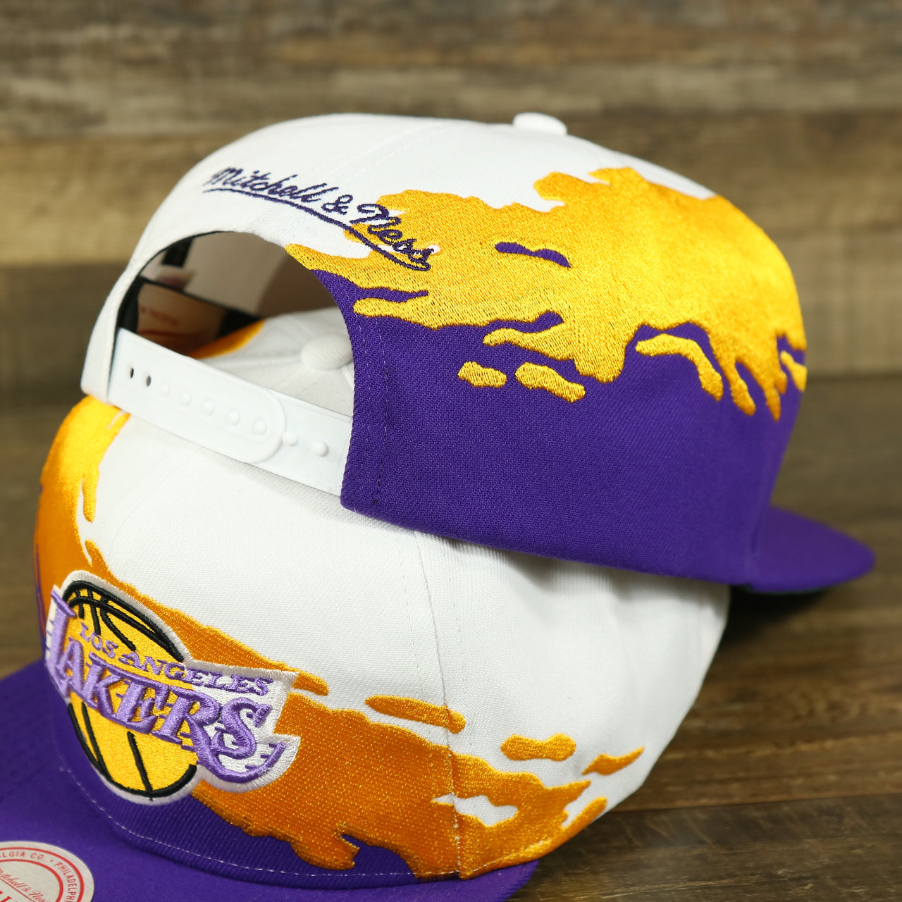 back of the Los Angeles Lakers Vintage Retro NBA Paintbrush Mitchell and Ness Snapback Hat | Purple/White/Yellow