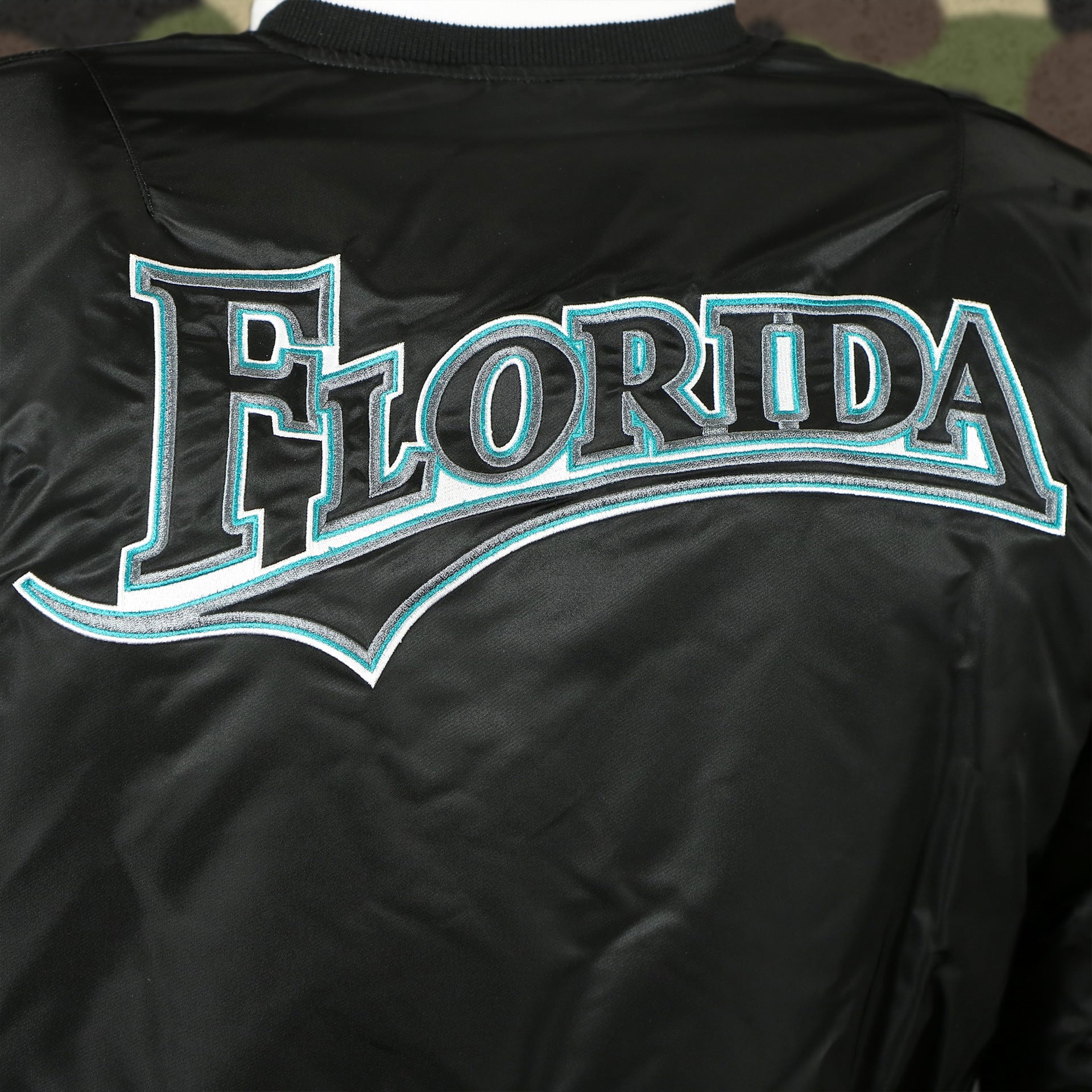 throwback marlins wordmark logo on the Florida Marlins MLB Patch Alpha Industries Reversible Bomber Jacket With Camo Liner | Black Bomber Jacket