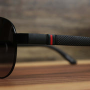 The red racing stripe on the Aviator Frame Racing Stripes Black Lens Sunglasses with Black Frame