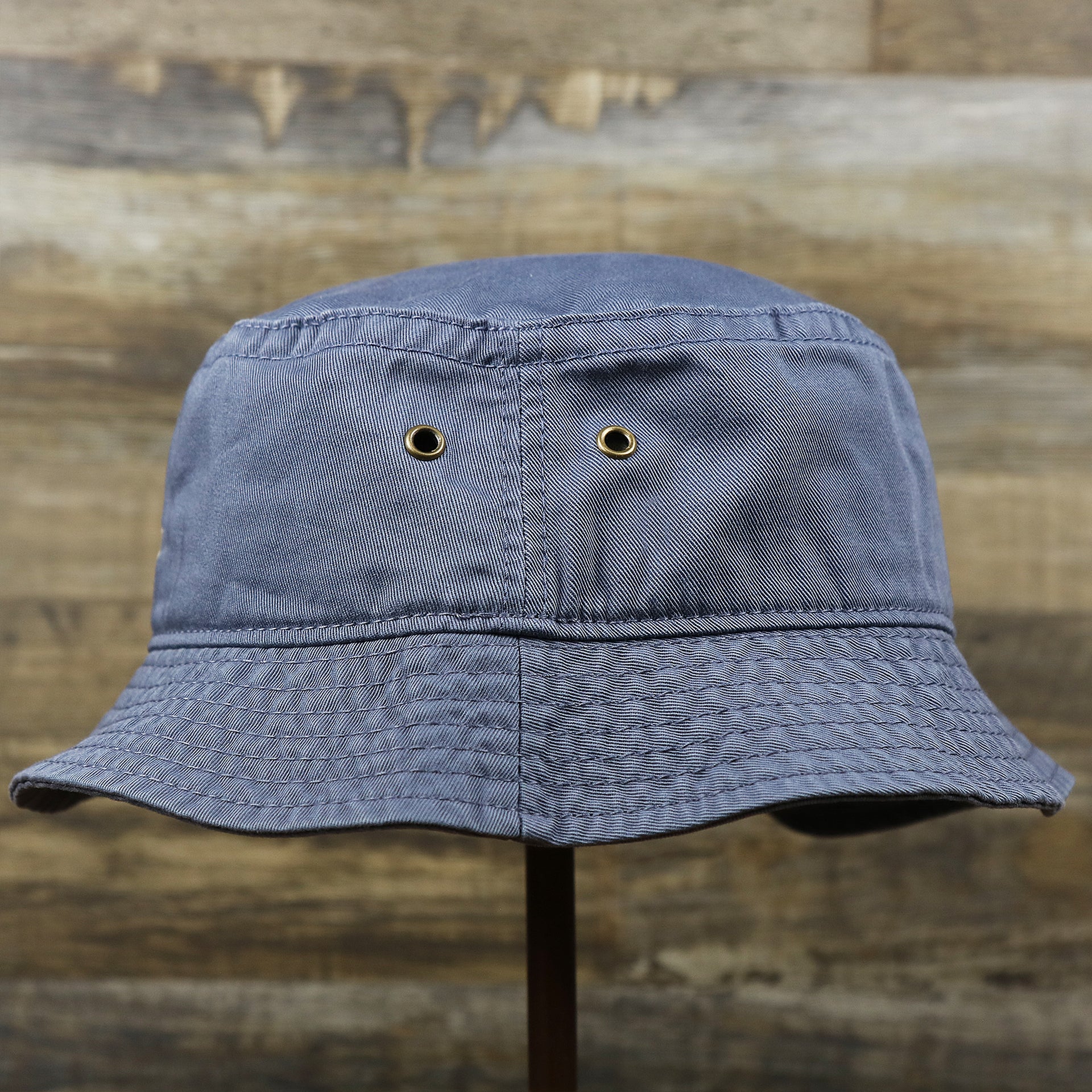 The wearer's left of the Ocean City Anchor New Jersey Wordmark Bucket Hat | Slate Blue Bucket Hat