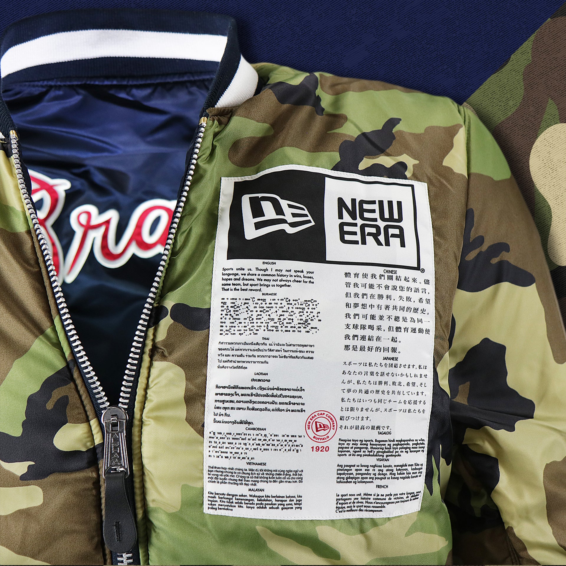 The New Era Sport Unite Us Graphic on the Atlanta Braves MLB Patch Alpha Industries Reversible Bomber Jacket With Camo Liner | Navy Blue Bomber Jacket