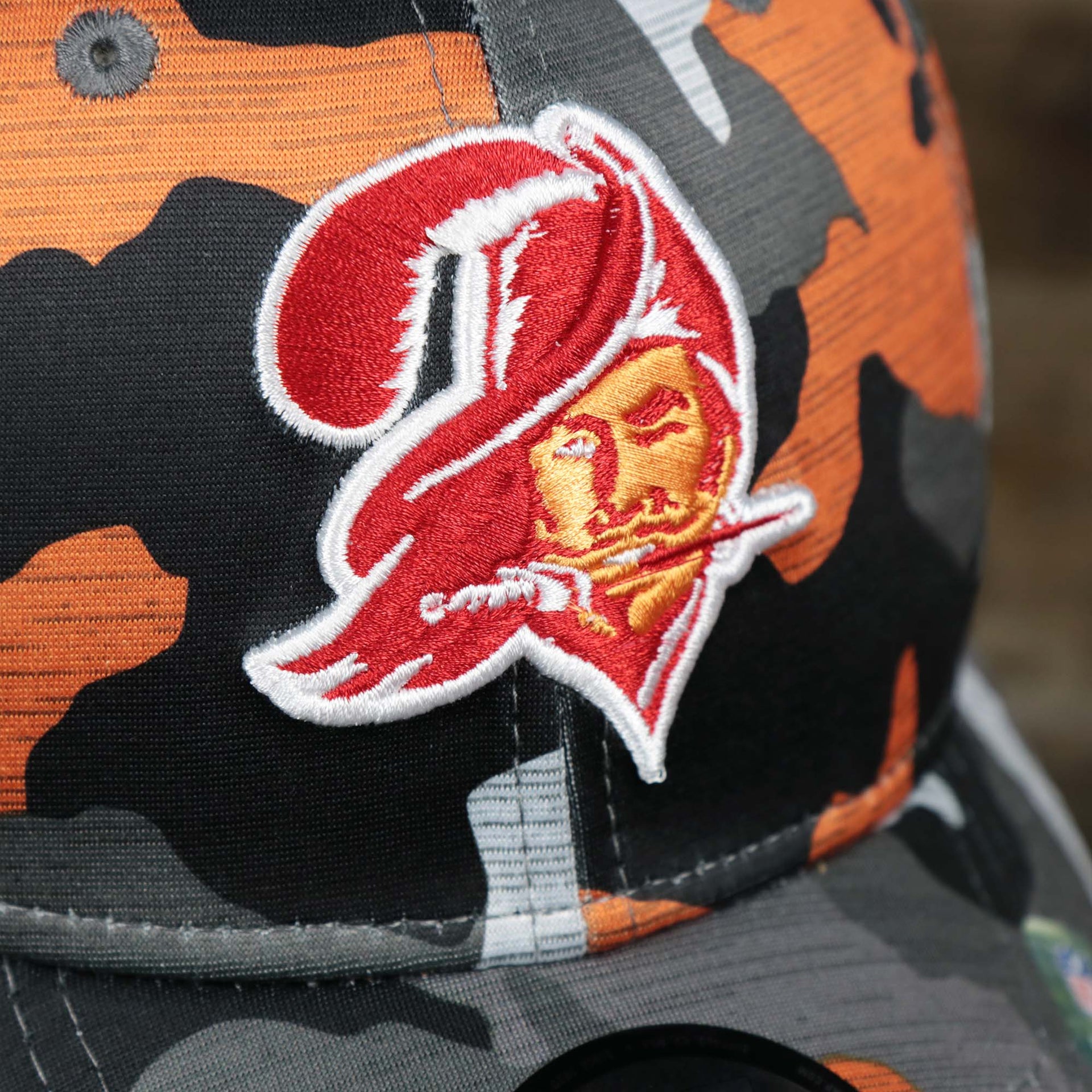 The buccaneers logo on the Throwback Tampa Bay Buccaneers OnField NFL Summer Training 2022 39Thirty Camo FlexFit Cap | New Era Orange