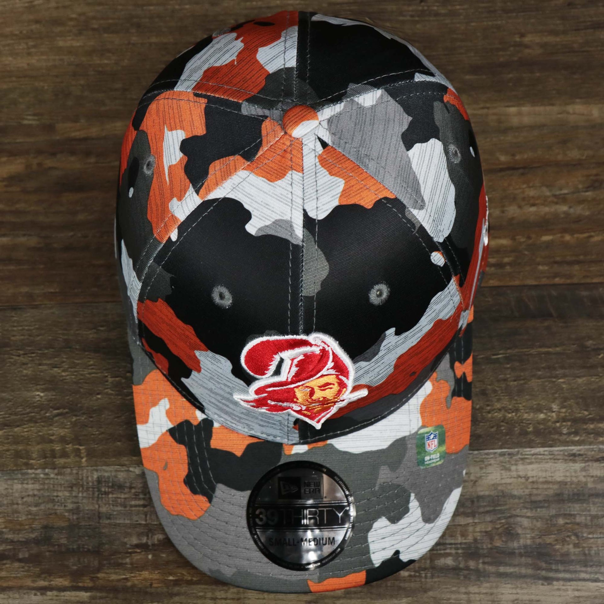 An overhead shot of the Throwback Tampa Bay Buccaneers OnField NFL Summer Training 2022 39Thirty Camo FlexFit Cap | New Era Orange
