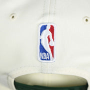 The NBA Jerry West Logo on the back of the Milwaukee Bucks NBA 2022 Draft Gray Bottom 9Fifty Snapback | New Era Cream/Green