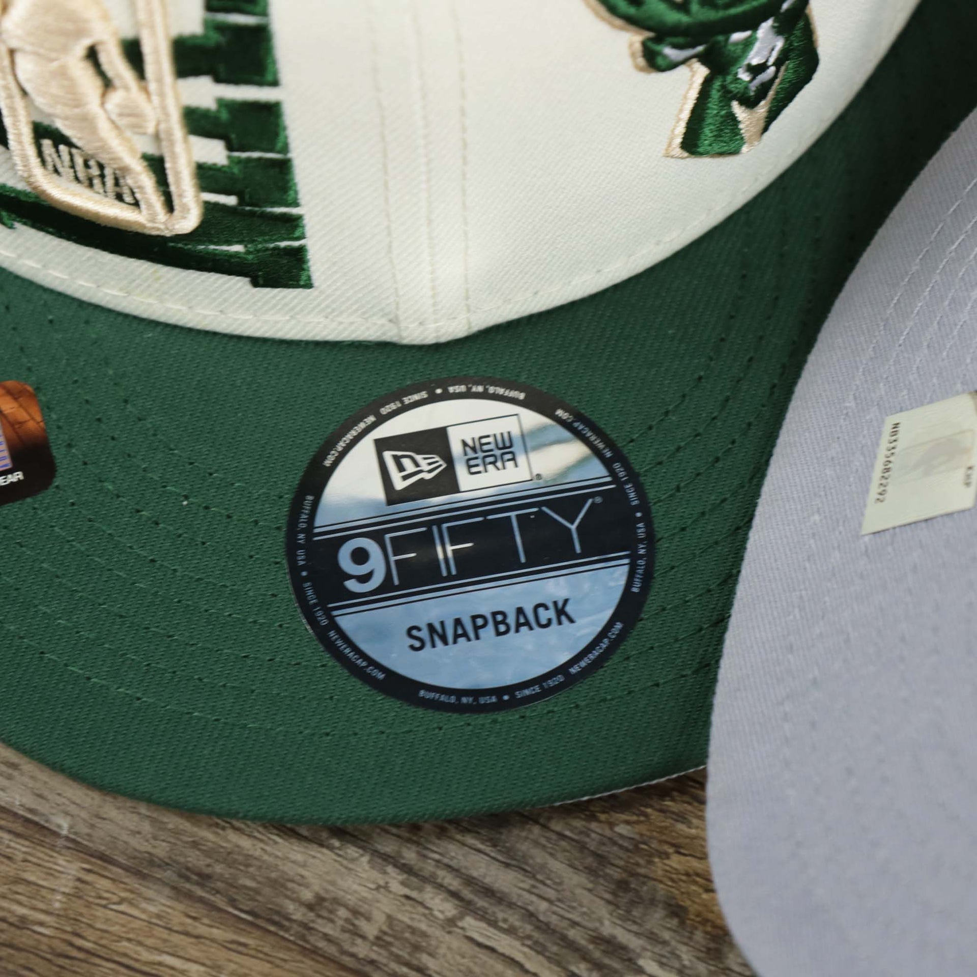 The 9Fifty Sticker on the Milwaukee Bucks NBA 2022 Draft Gray Bottom 9Fifty Snapback | New Era Cream/Green