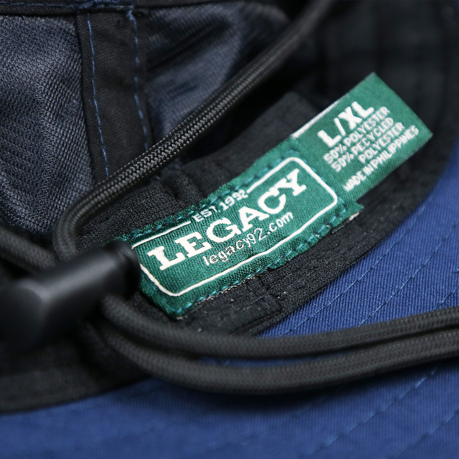 The legacy tag on the Ocean City Wordmark Parallel Oars New Jersey Bucket Hat | Navy Blue Bucket Hat