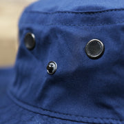 The buttons on the Ocean City Wordmark Parallel Oars New Jersey Bucket Hat | Navy Blue Bucket Hat