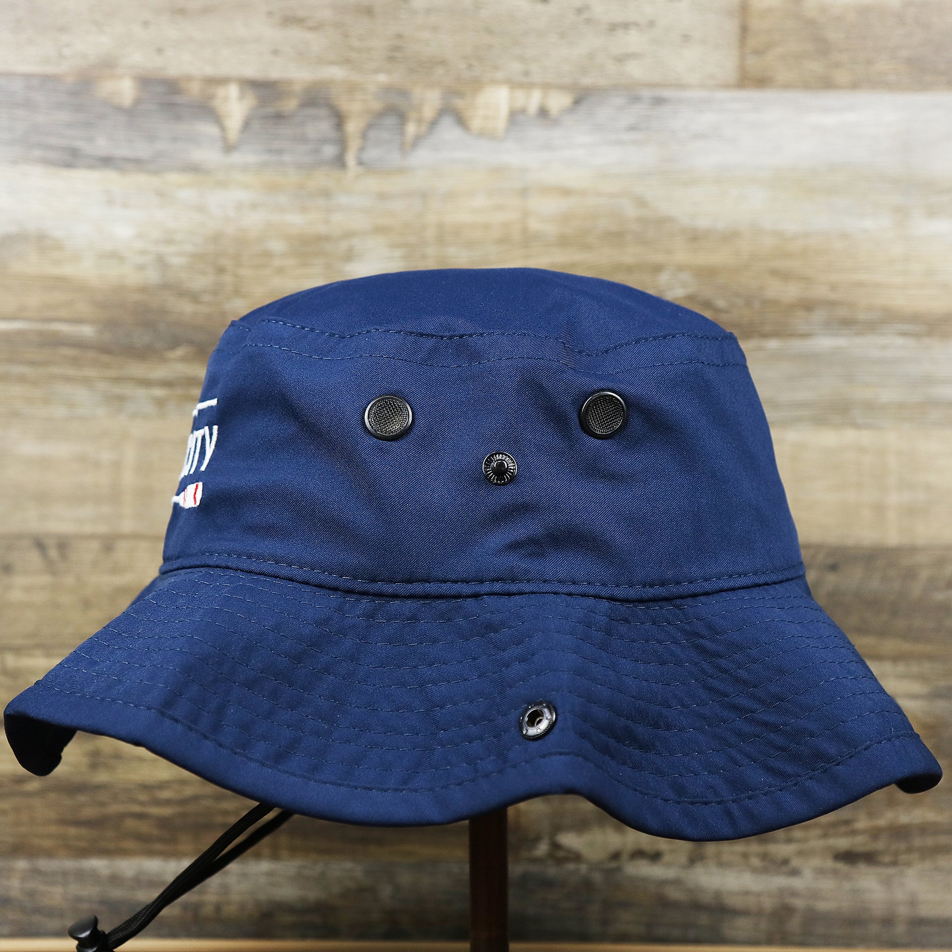 The wearer's left on the Ocean City Wordmark Parallel Oars New Jersey Bucket Hat | Navy Blue Bucket Hat