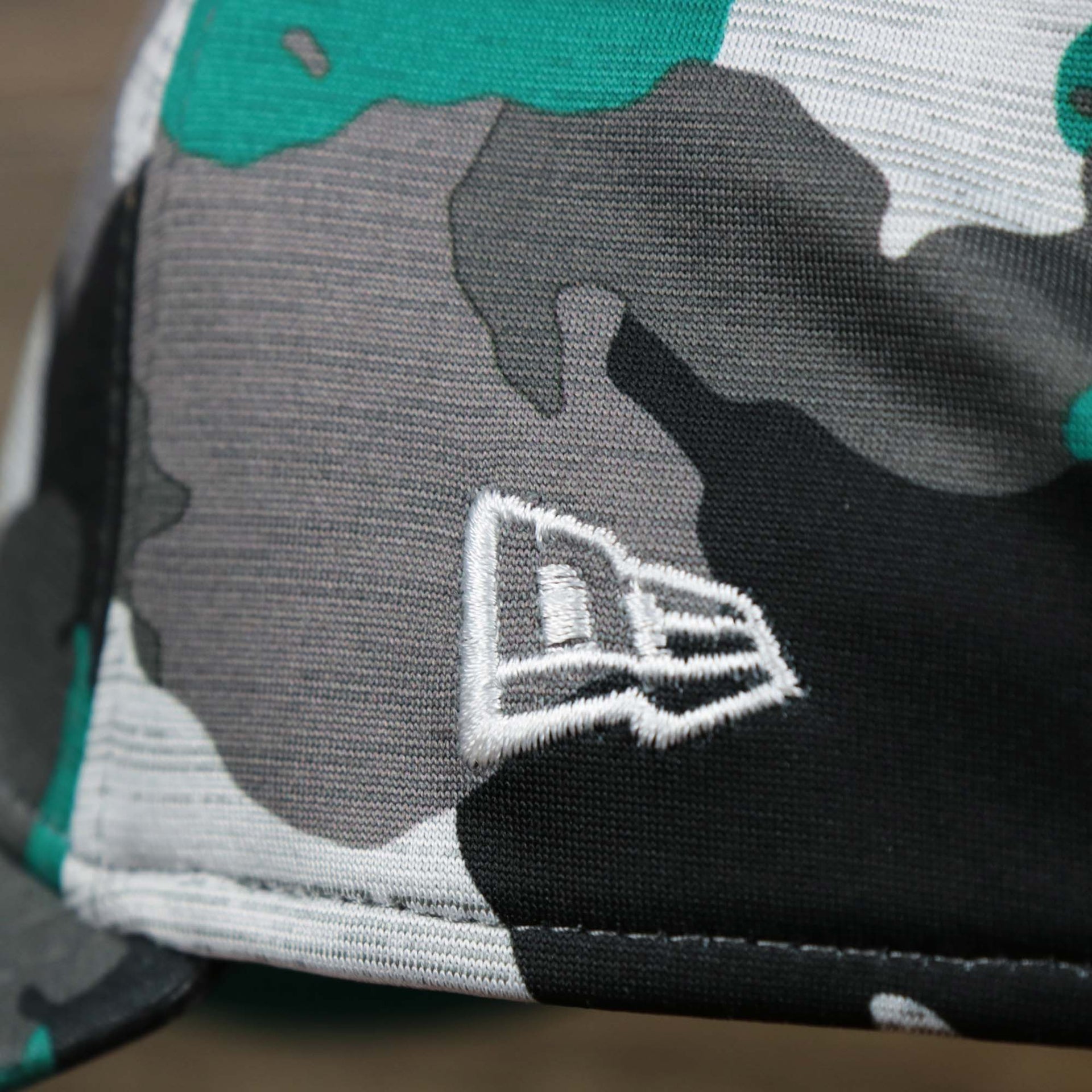 The New Era logo on the Throwback Miami Dolphins OnField NFL Summer Training 2022 39Thirty Camo FlexFit Cap | New Era Turquoise