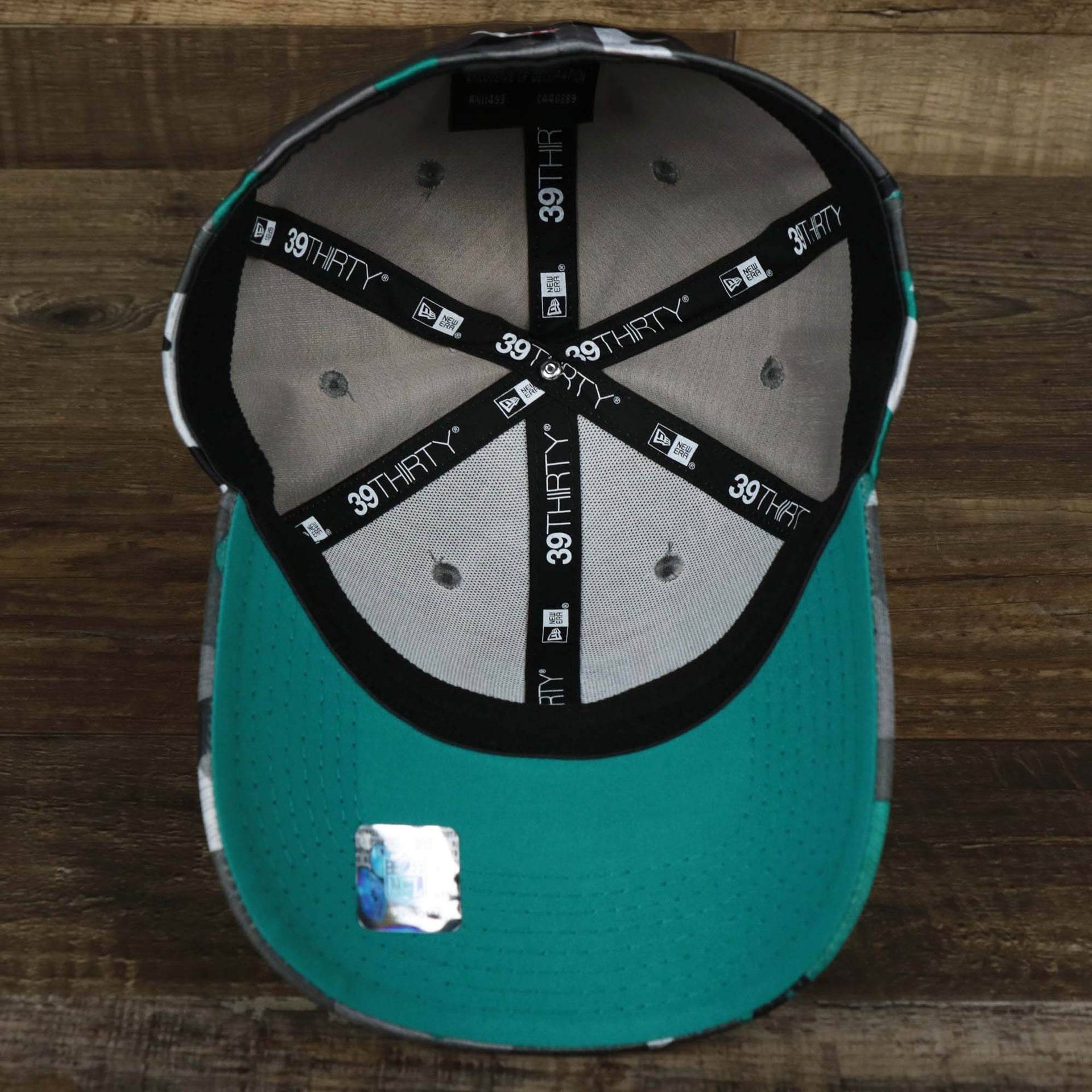 The underside of the Throwback Miami Dolphins OnField NFL Summer Training 2022 39Thirty Camo FlexFit Cap | New Era Turquoise