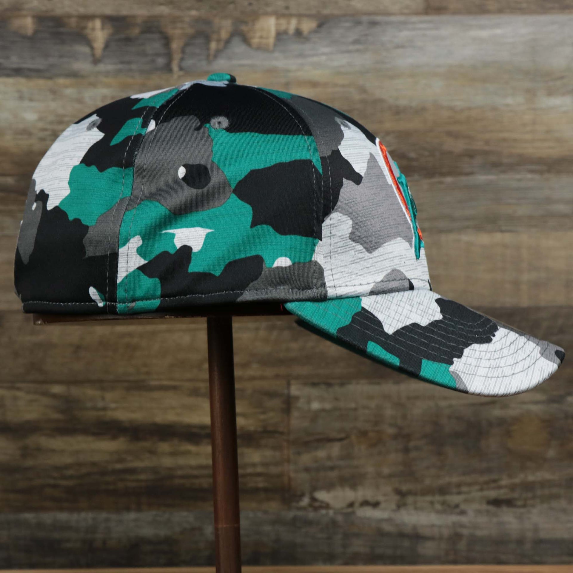 The wearer's right on the Throwback Miami Dolphins OnField NFL Summer Training 2022 39Thirty Camo FlexFit Cap | New Era Turquoise