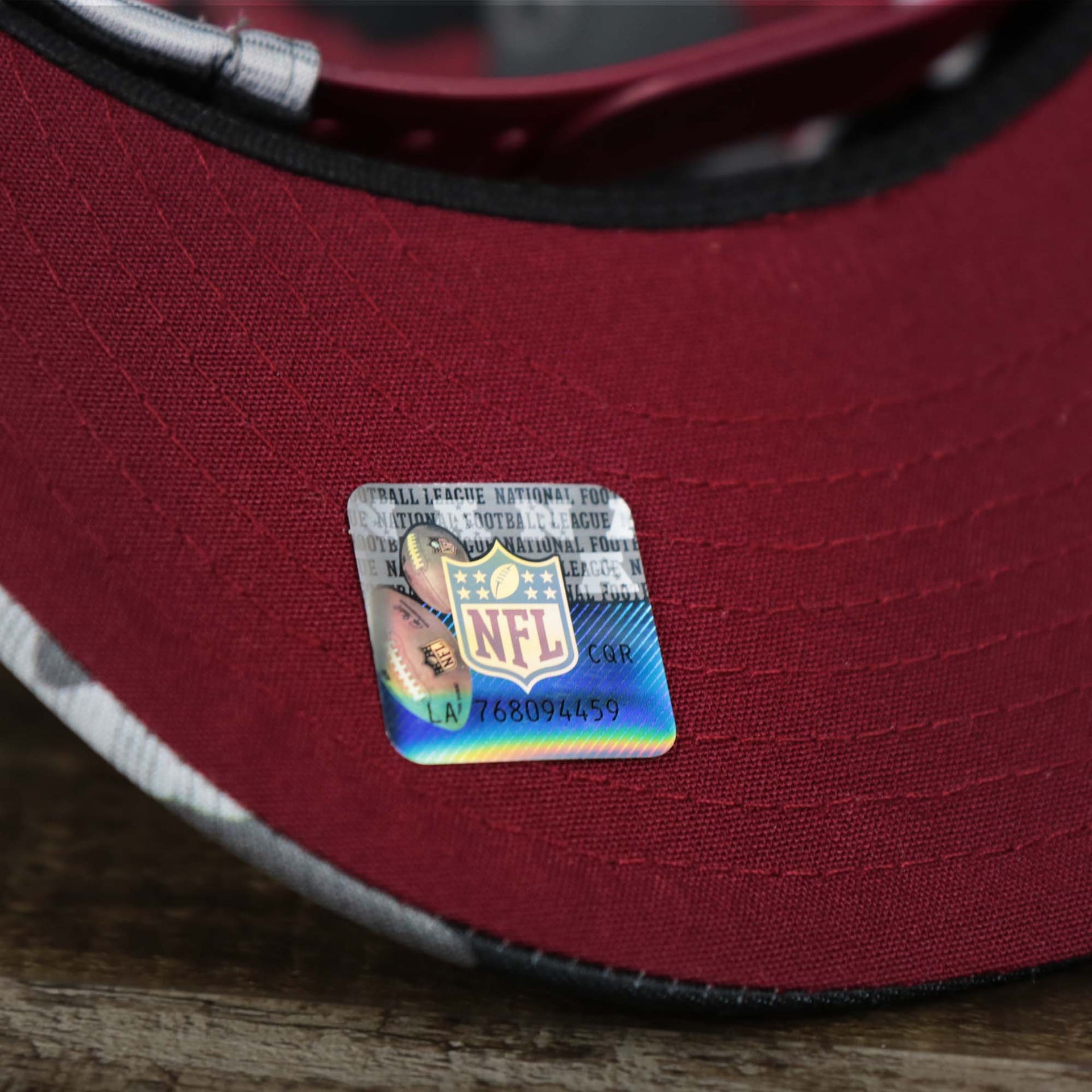 The NFL Sticker on the visor of the Washington Commanders NFL OnField Summer Training 2022 Camo 9Fifty Snapback | Burgundy Camo 9Fifty