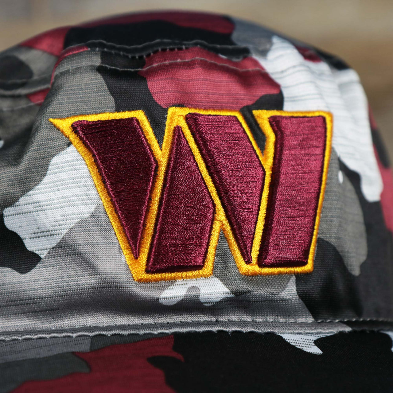 The Washington Logo on the Washington Commanders NFL Summer Training Camp 2022 Camo Bucket Hat | Burgundy Bucket Hat